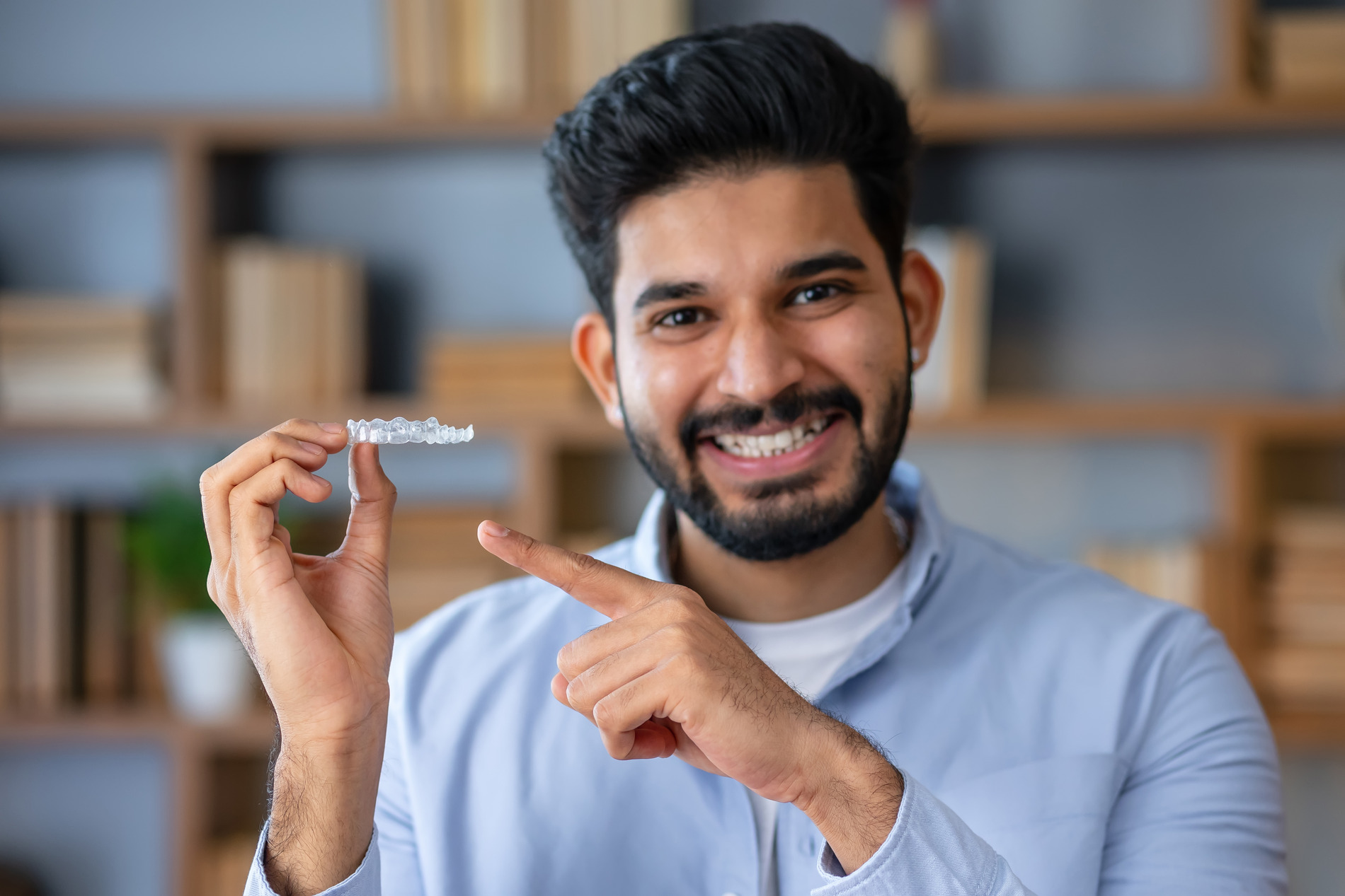 Man showing his invisalign aligners from Dr. Cooperman and Dr. Romao